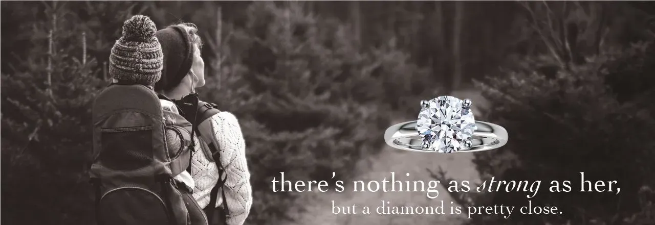 Couple hiking in nature, showcasing a diamond ring. 