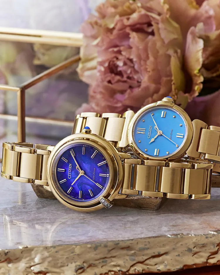 Two elegant Citizen watches with gold bands, one featuring a blue face and the other a light blue face.