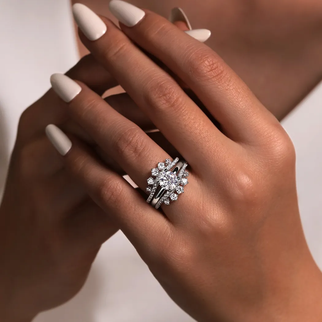 Elegant diamond engagement ring set on a hand with manicured nails.