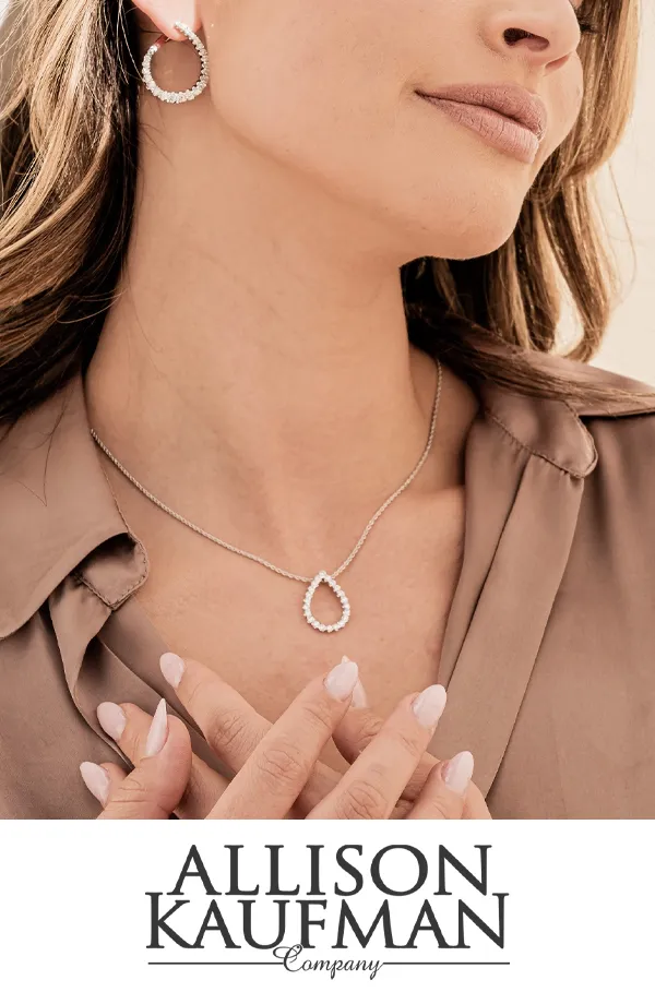 Model wearing silver jewelry, including earrings and a necklace.