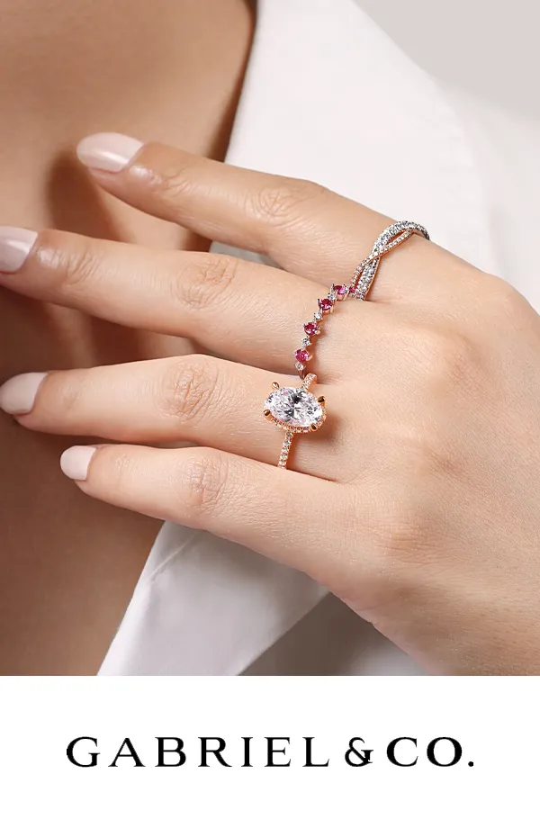 Elegant rings featuring a large center stone and colorful accents, displayed on a hand.