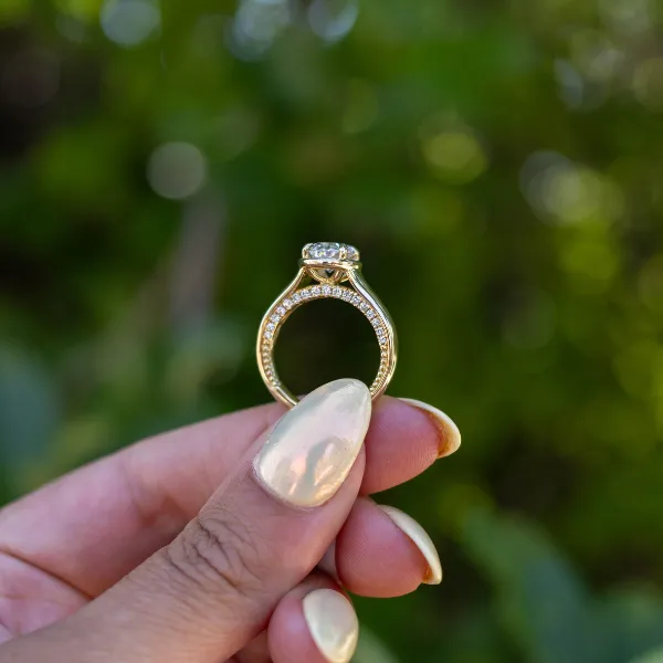 Intricate engagement ring with a central diamond and detailed filigree design, showcasing fine craftsmanship.