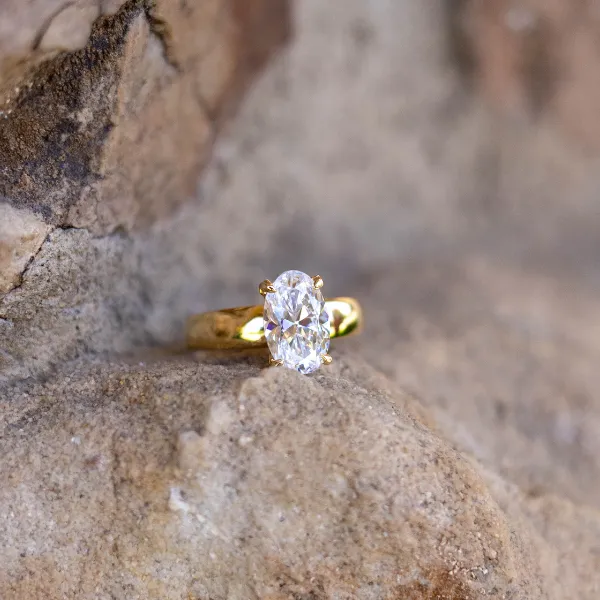 Three elegant diamond rings displayed on a stone surface, showcasing various styles. Visit Sather's Leading Jewelers.