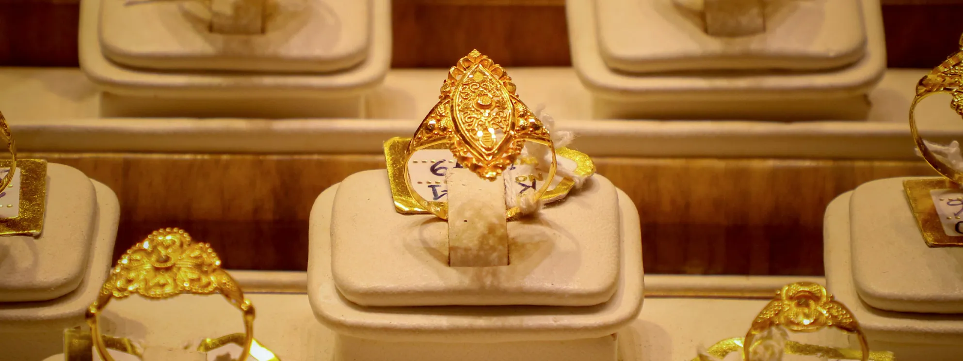 Gold ring with intricate design displayed in a jewelry store.