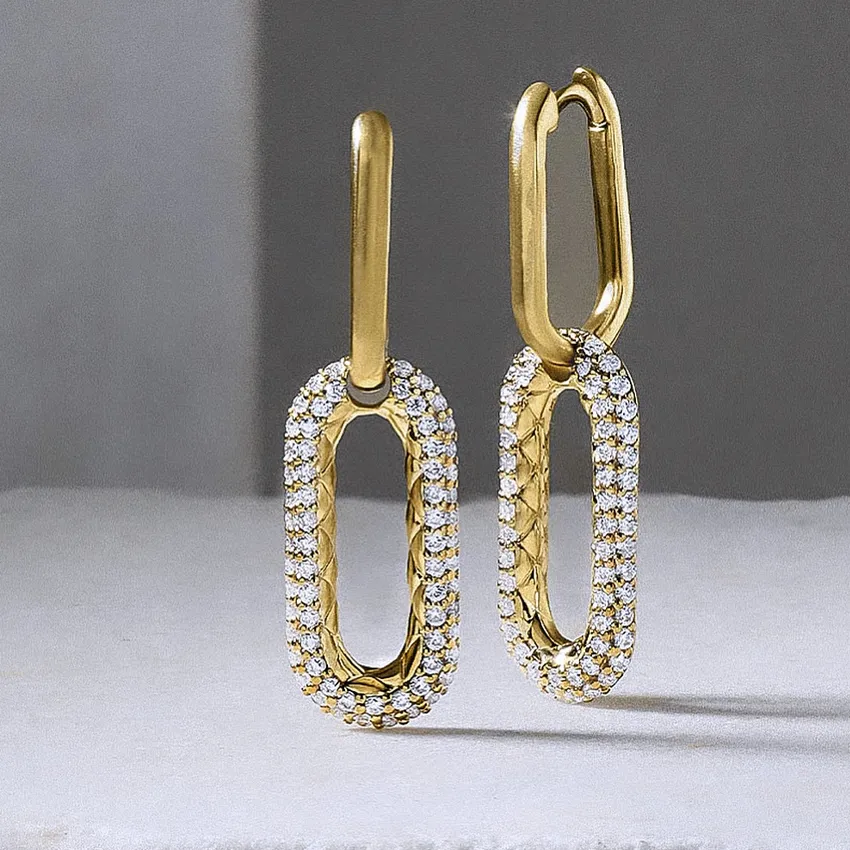 Gold earrings with diamond accents in a unique oval design.