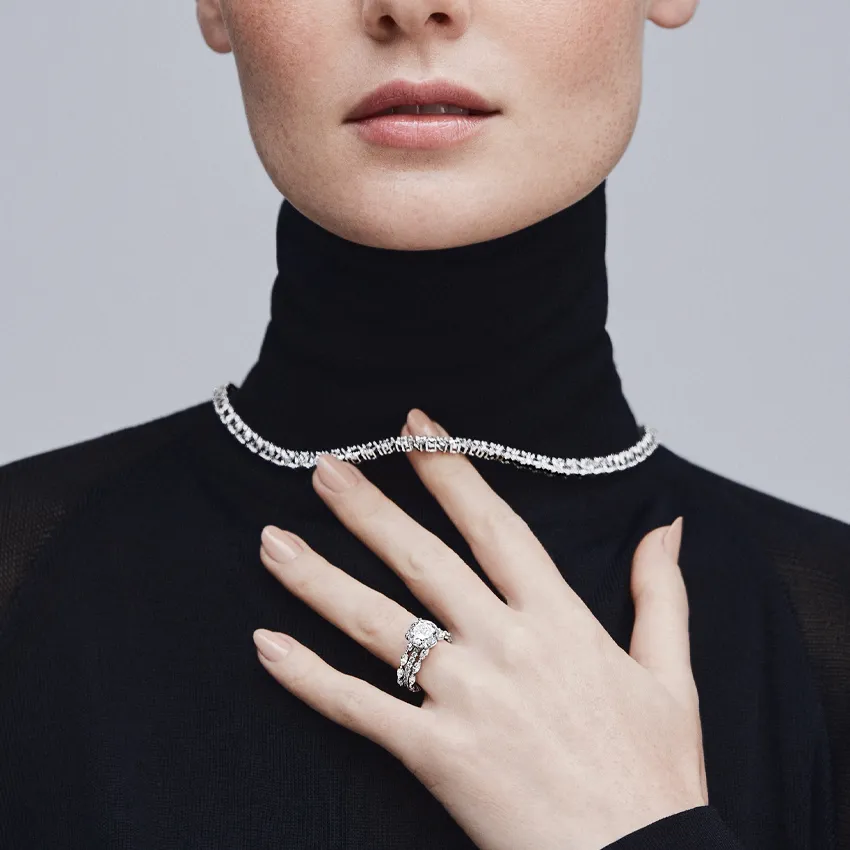 Elegant woman wearing a diamond necklace and engagement ring.