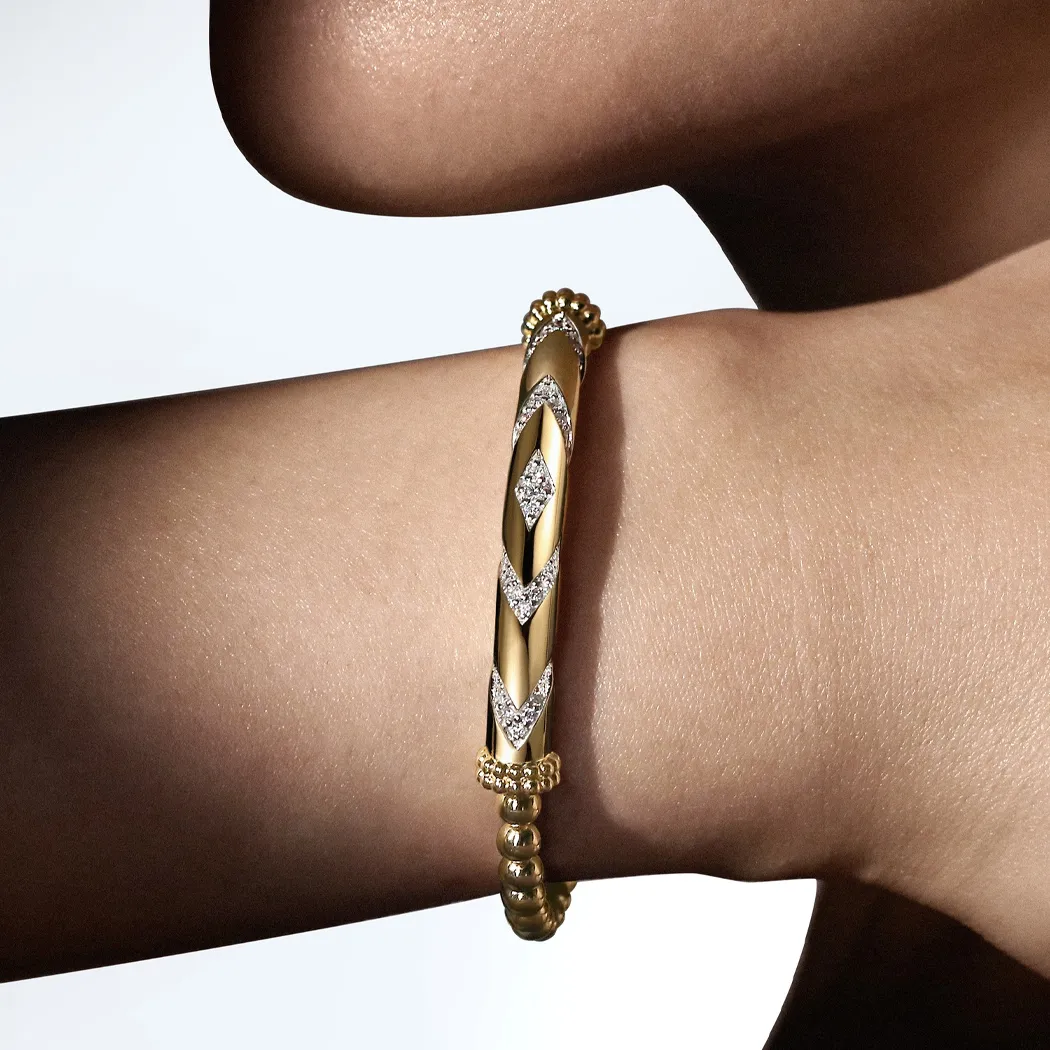 Elegant gold and diamond bracelet on a wrist, showcasing fine jewelry craftsmanship.
