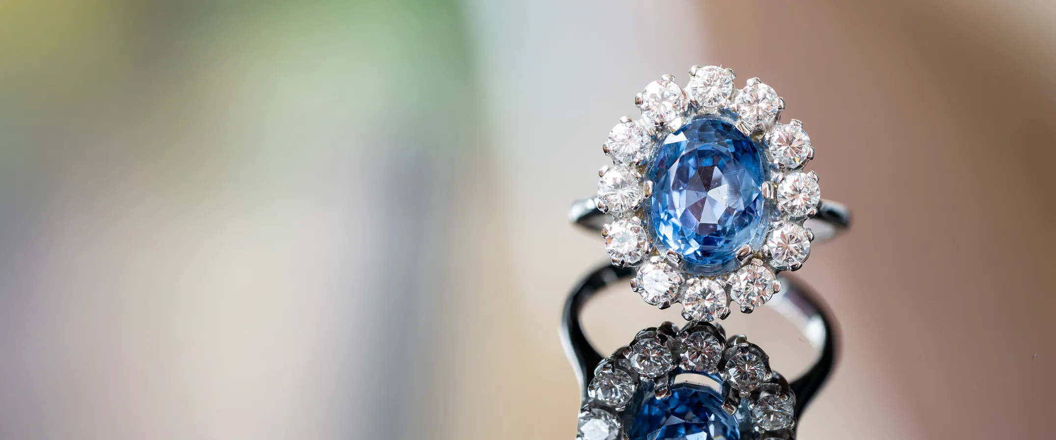 Elegant blue gemstone ring surrounded by sparkling diamonds, reflecting beautifully.