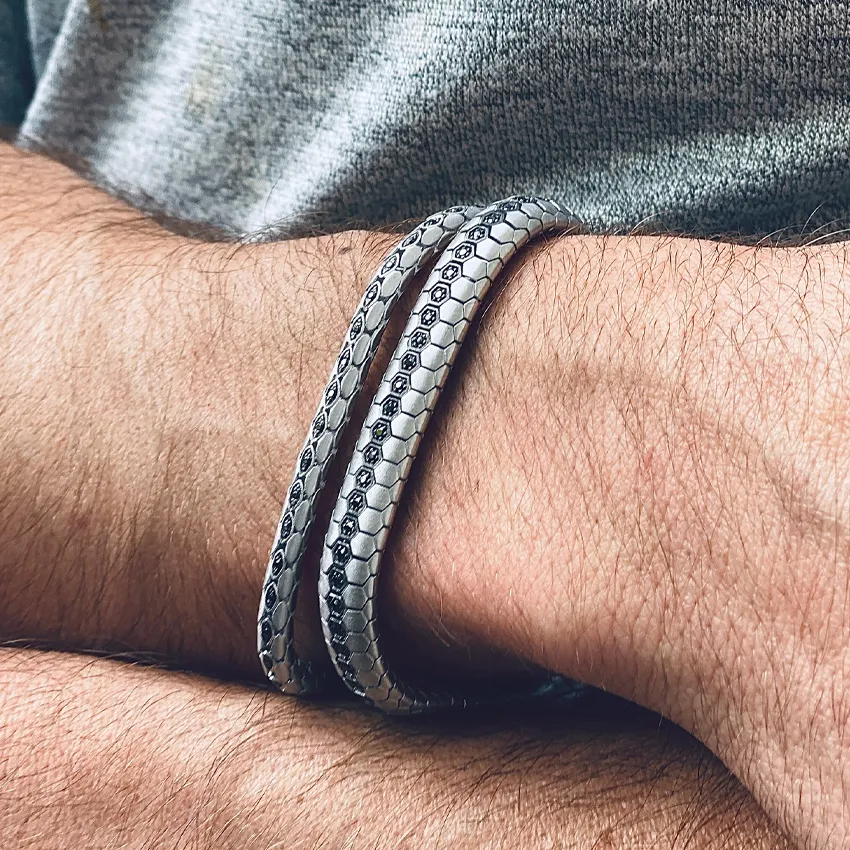 Silver hexagonal patterned bracelets on a man's wrist, showcasing stylish men's jewelry from Sather's Leading Jewelers.