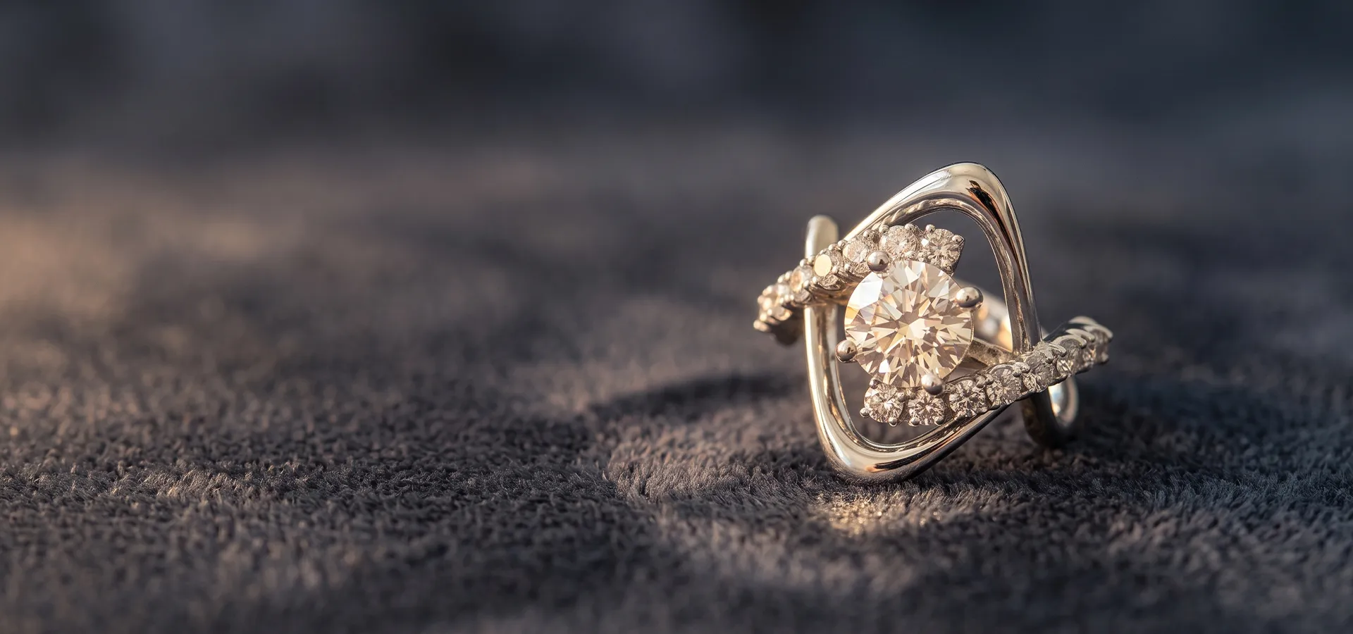 A diamond ring with intricate design on a textured surface.