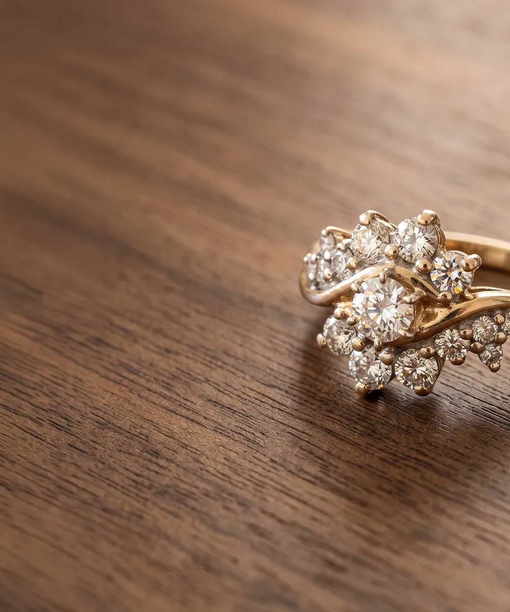 A gold ring with multiple sparkling diamonds on a wooden surface.