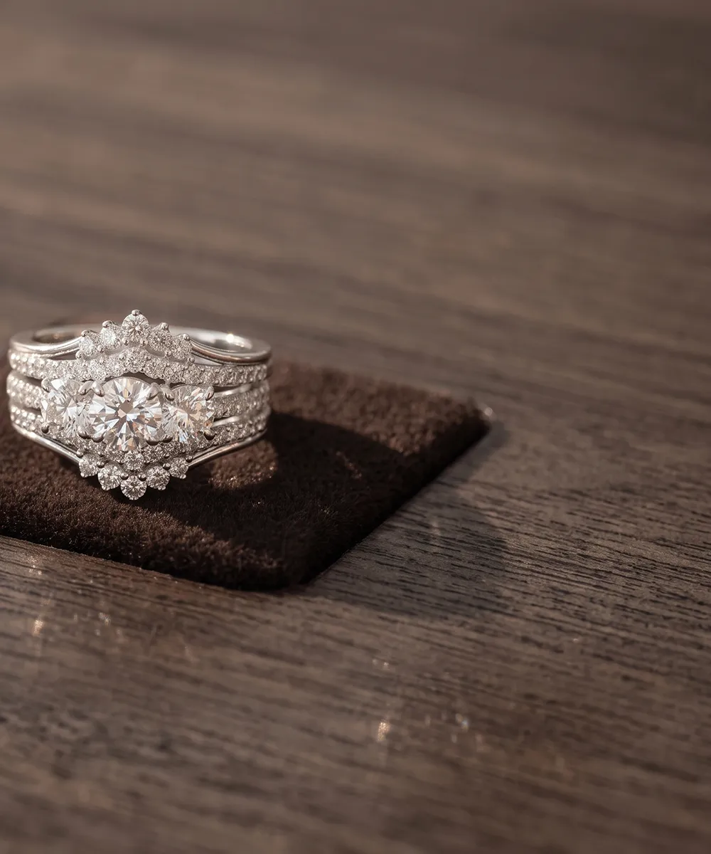 A diamond ring with intricate detailing on a wooden surface.