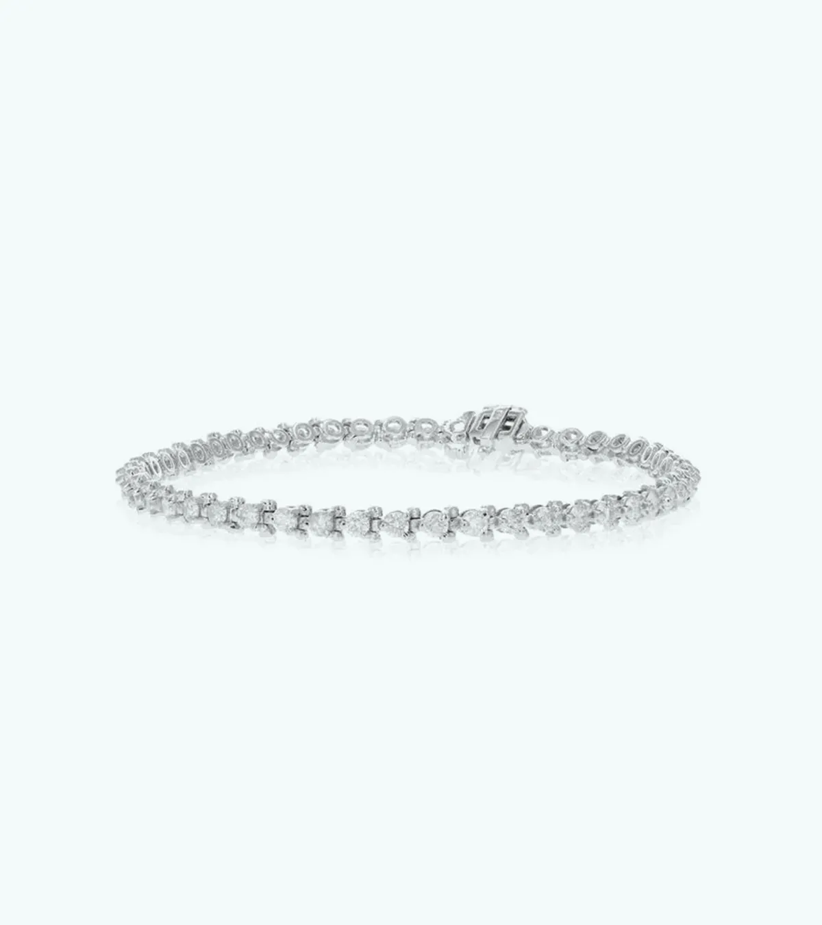 A delicate silver tennis bracelet with small round diamonds on a light background.