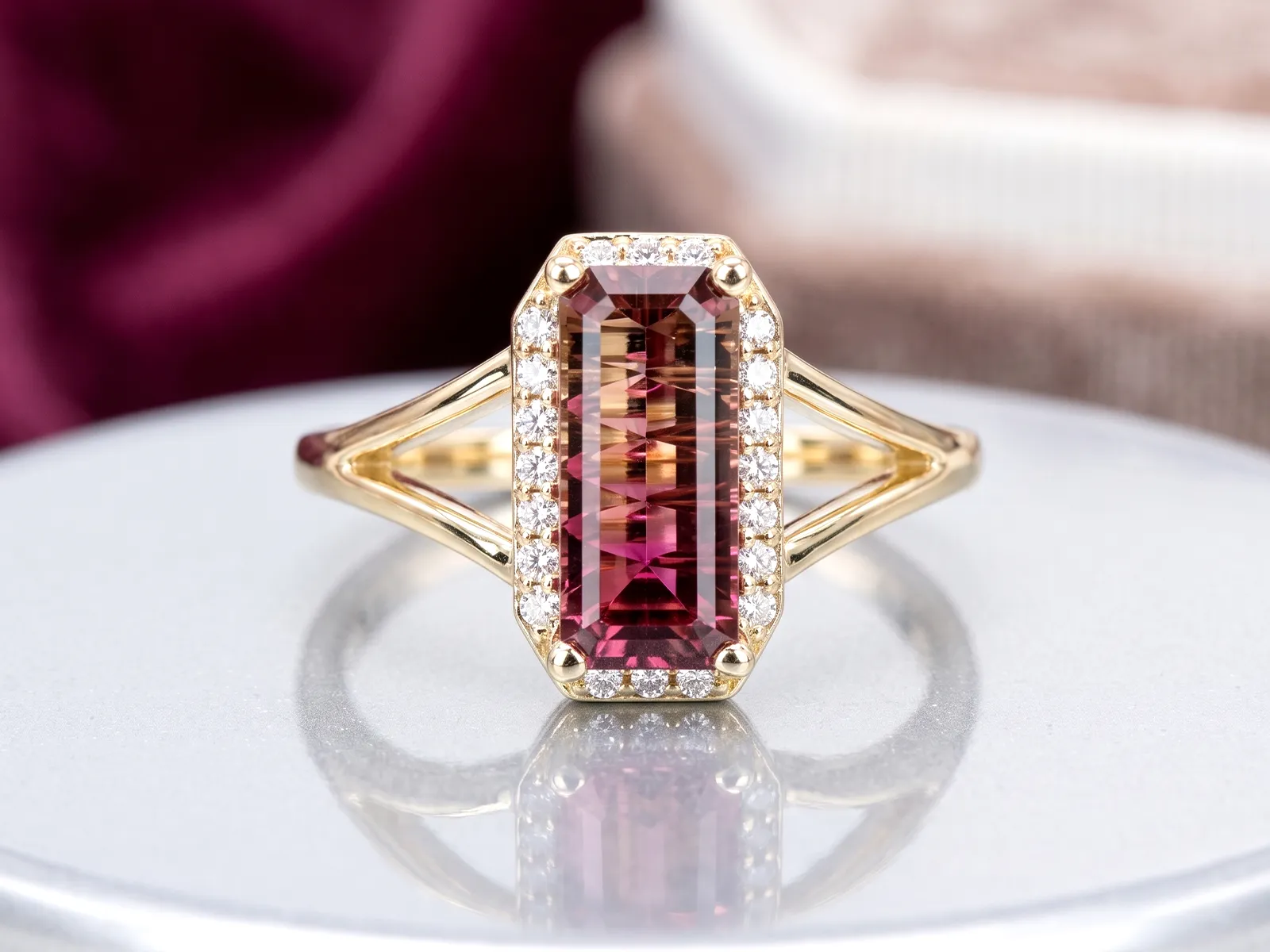A gold ring with a rectangular pink gemstone surrounded by small diamonds.
