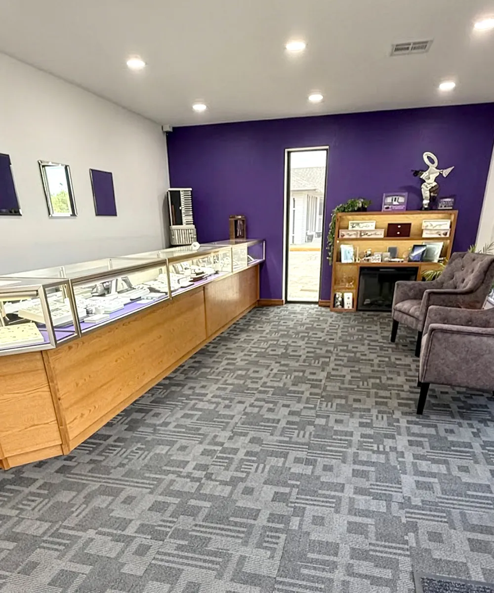 A jewelry store interior with display cases, purple walls, and seating area.