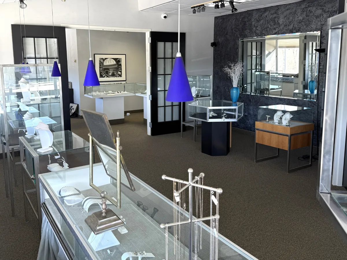 Jewelry store interior with glass display cases and blue pendant lights.