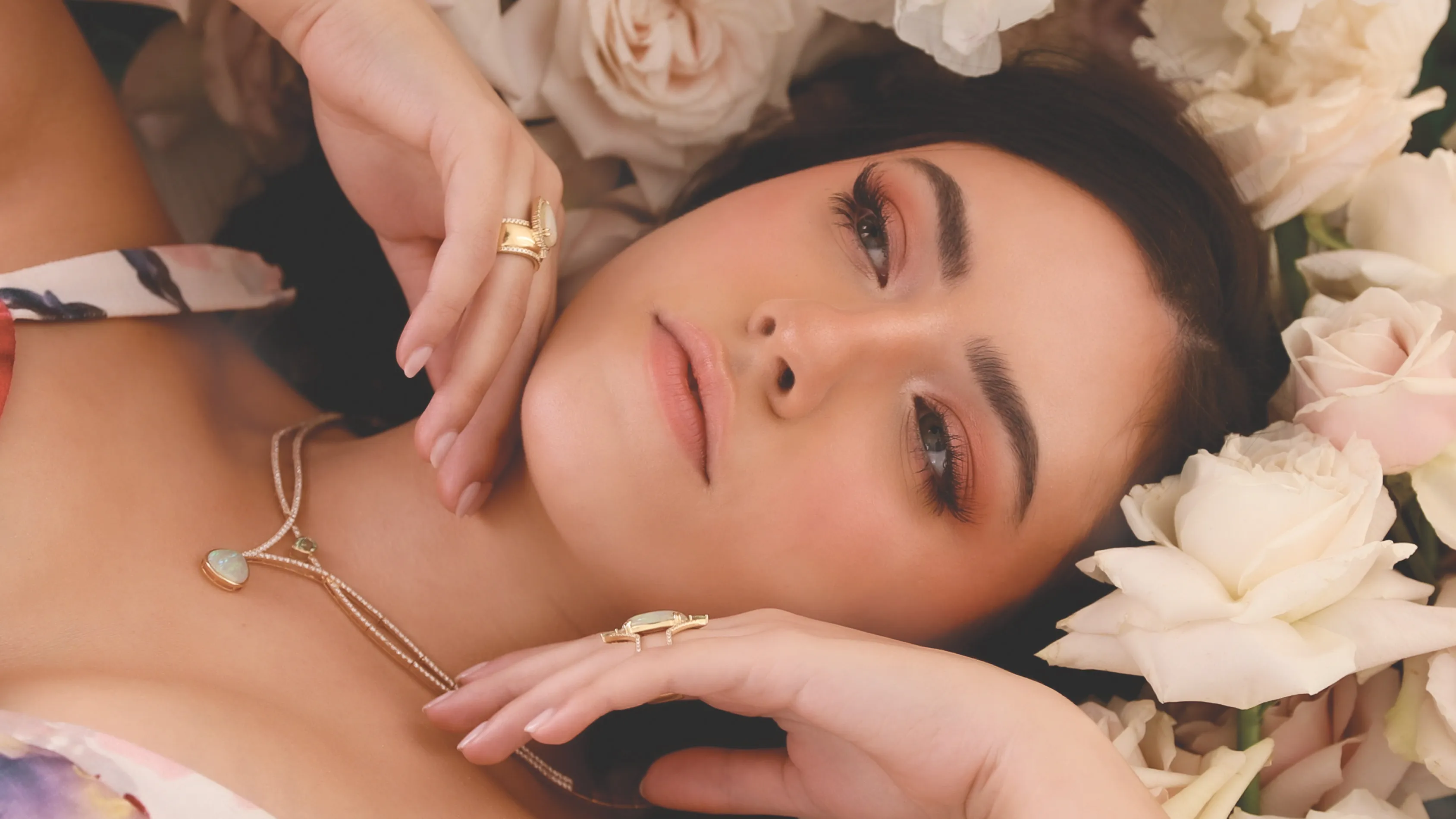 Three elegant gold rings featuring large green gemstones, displayed on a soft background.
