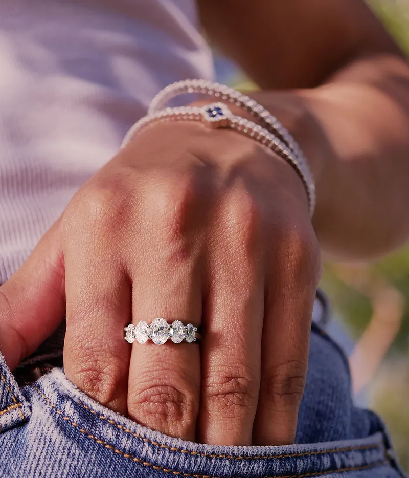 Close-up of a hand wearing a sparkling diamond ring and bracelets.