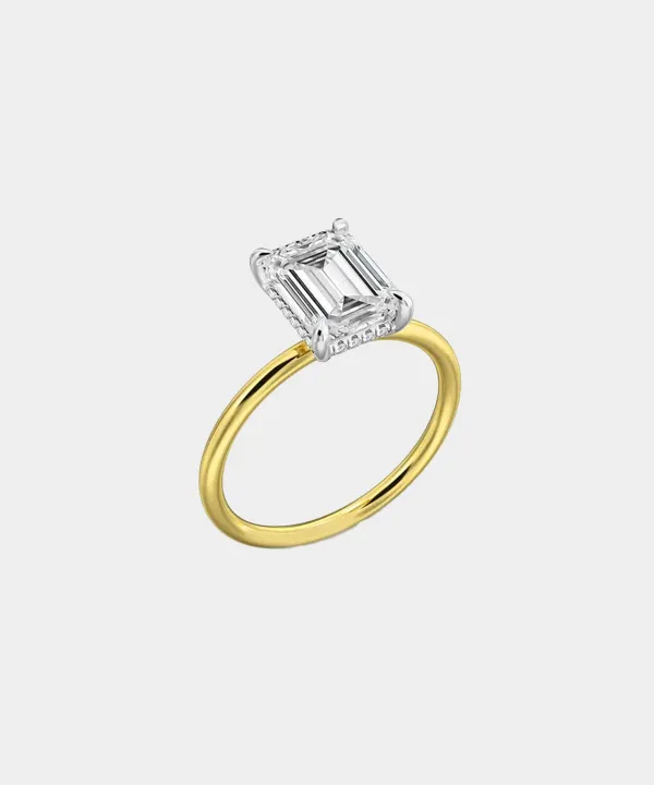 Elegant yellow gold engagement ring featuring a large emerald-cut diamond centerpiece.