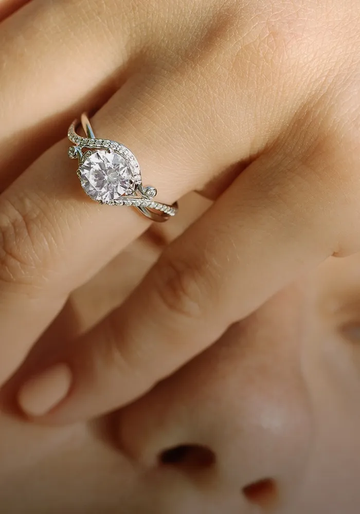 Elegant woman showcasing a diamond engagement ring and earrings.