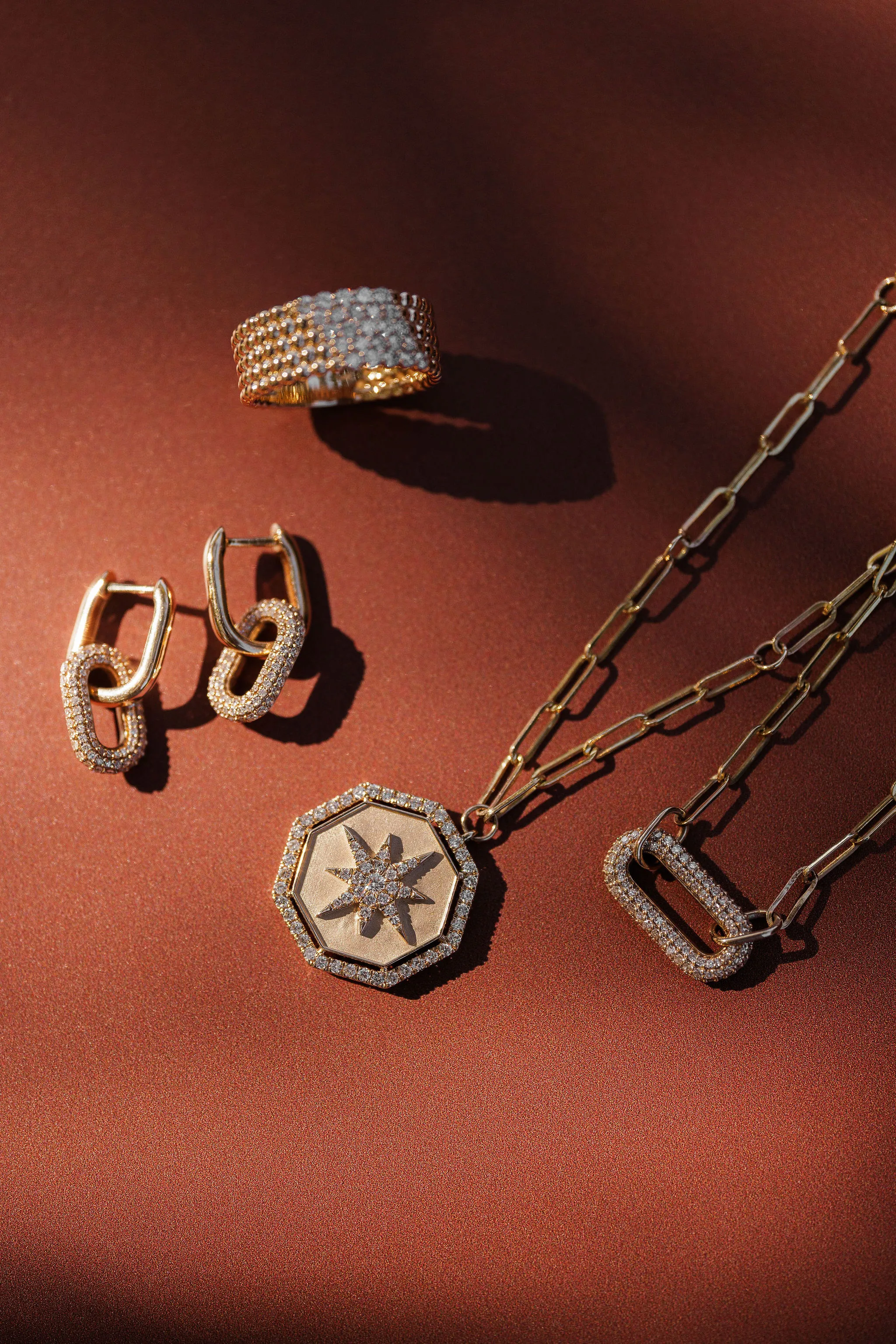 Three sparkling diamonds in various cuts on a textured surface, showcasing their brilliance and clarity.