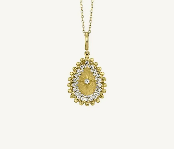 Gold teardrop pendant with diamond accents on a chain, perfect for gifting.