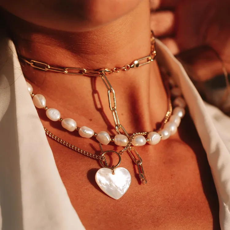 Layered gold and pearl necklaces with a heart pendant. Click to shop at Simones Jewelry.