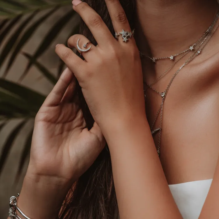 Woman wearing moon and star-themed diamond rings and necklaces. Click to shop at Simones Jewelry.
