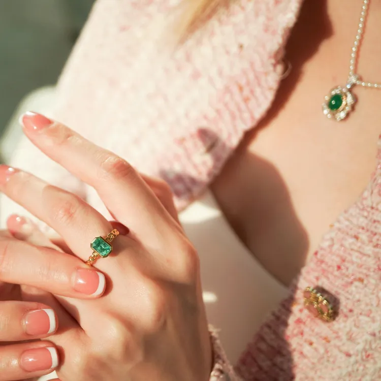 Model showcasing a green gemstone ring and necklace. Click to Shop Now at Simones Jewelry.