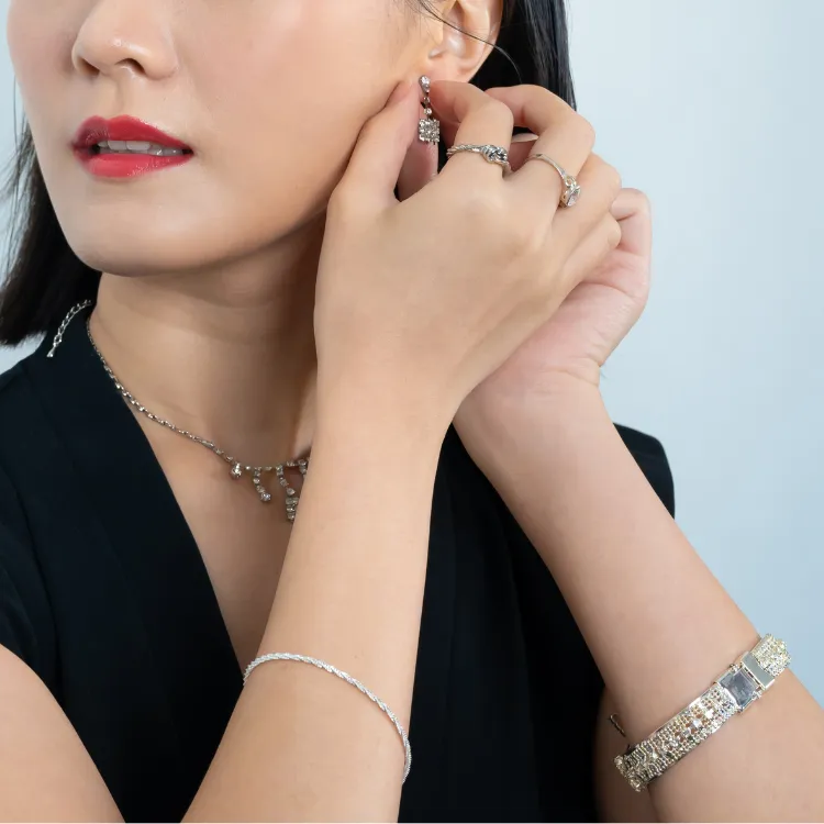 Woman wearing lab-grown diamond jewelry, including earrings, rings, and bracelets. Click to shop at Simones Jewelry.
