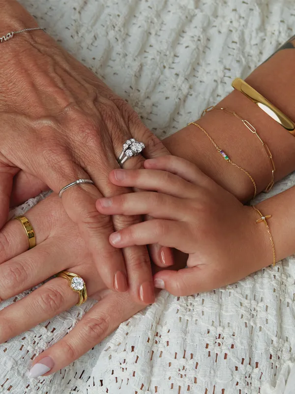 Hands of different generations adorned with various rings and bracelets, symbolizing family and love. Click to explore children'