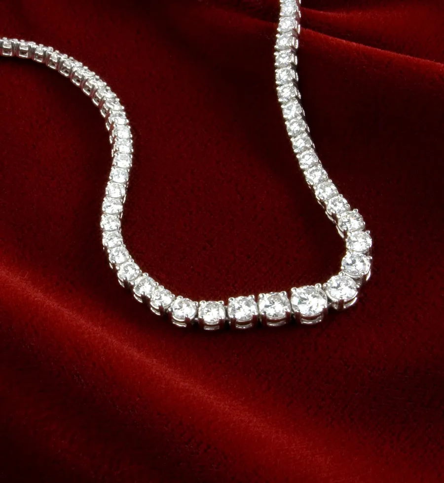 Elegant diamond necklace on red velvet, showcasing fine jewelry.