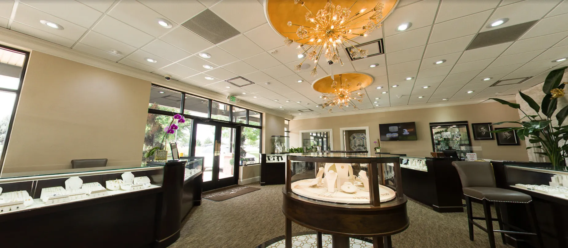 Six staff members of Snyder Jewelers pose in their store, showcasing fine jewelry and a welcoming atmosphere.