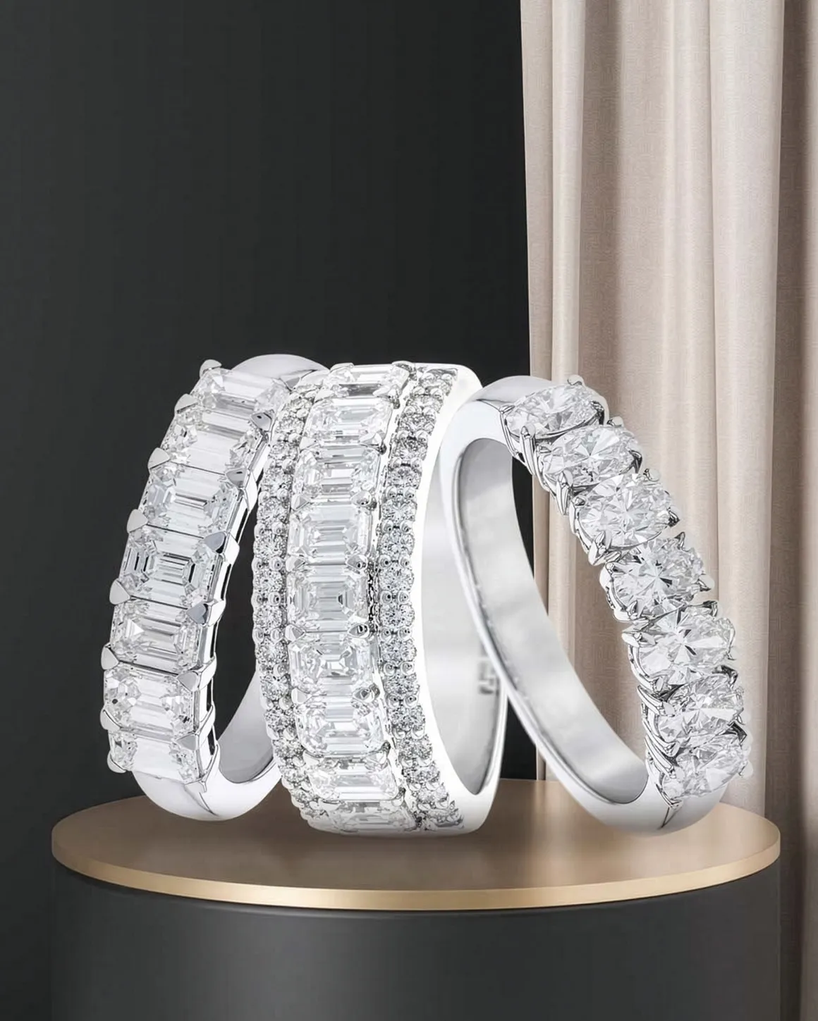 Three elegant diamond rings displayed on a pedestal, showcasing various styles.