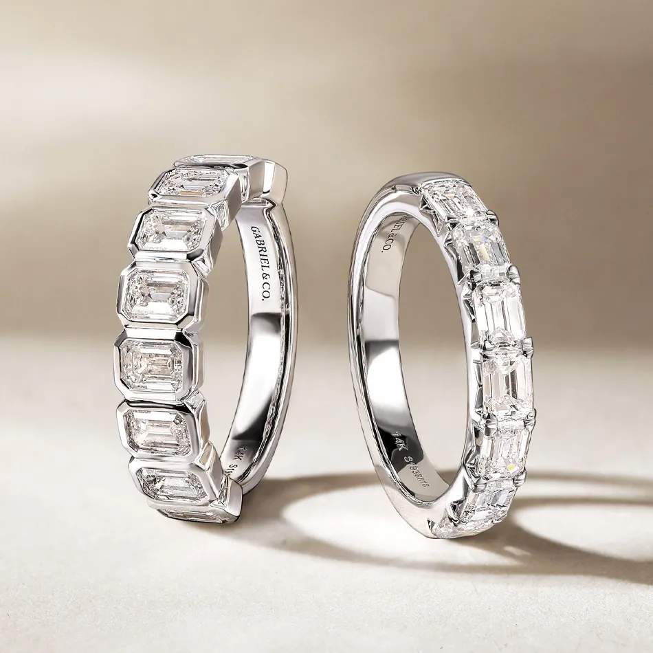 Two elegant women's wedding bands featuring emerald-cut diamonds.