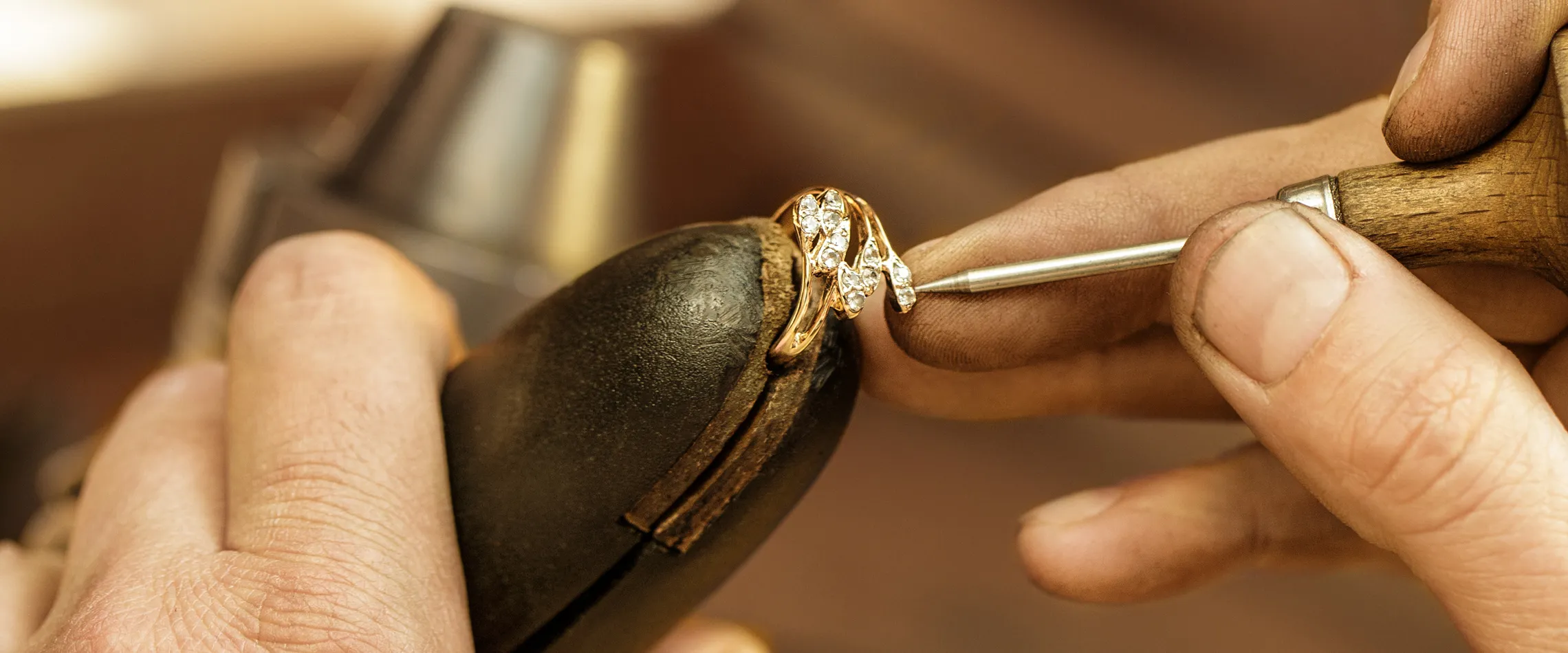 Jeweler restoring a diamond ring with precision tools at Synder Jewelers in Longmont. Learn more about our restoration services.