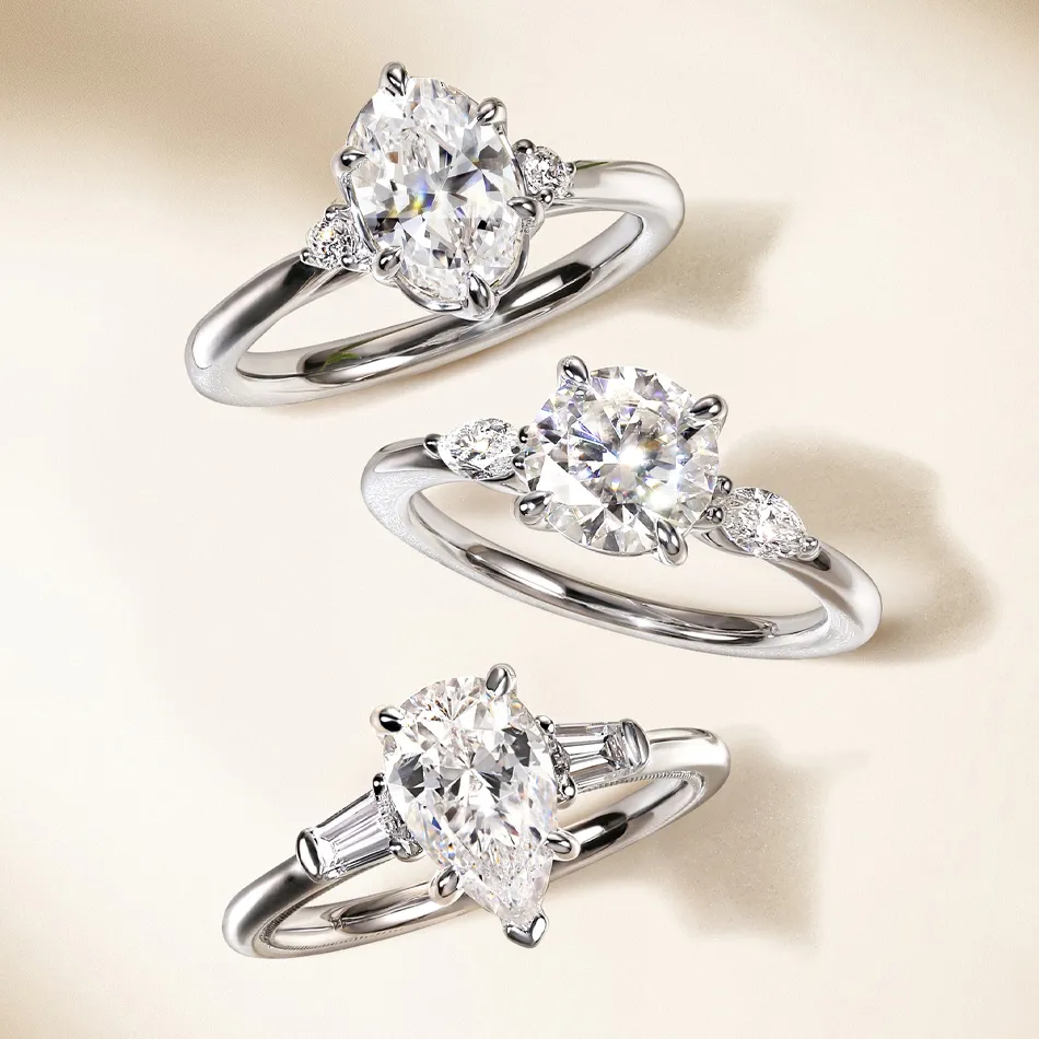 Three elegant engagement rings featuring various diamond cuts, displayed on a soft background. Visit Synder Jewelers for more.