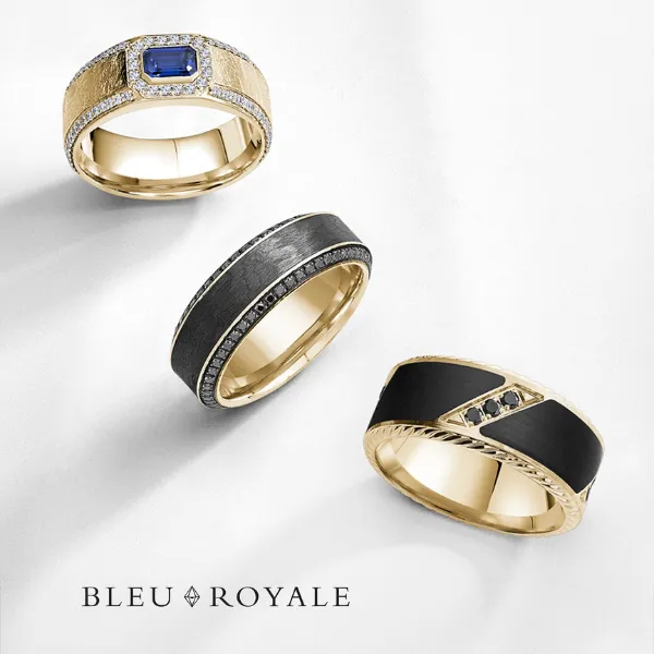 Bleu Royale men's wedding bands in black with yellow gold edges, rose gold inlays, and blue sapphire accent — SVS Fine Jewelry