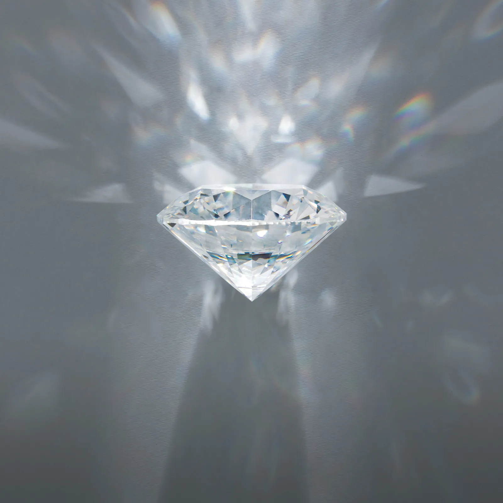 A sparkling diamond with light reflections on a gray background.
