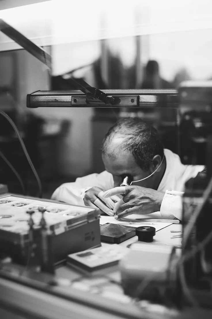 A hand holding a sparkling silver ring with a pink stone, showcasing jewelry appraisal services.