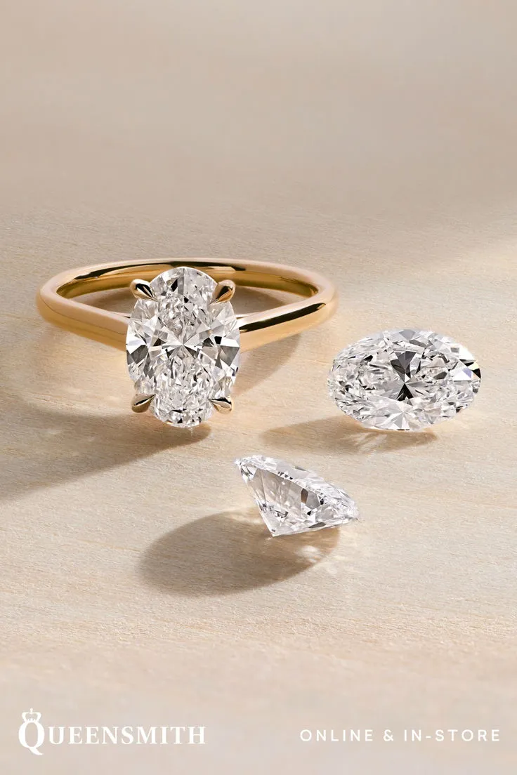 Close-up of a hand wearing a sparkling engagement ring with a large center stone and delicate band.