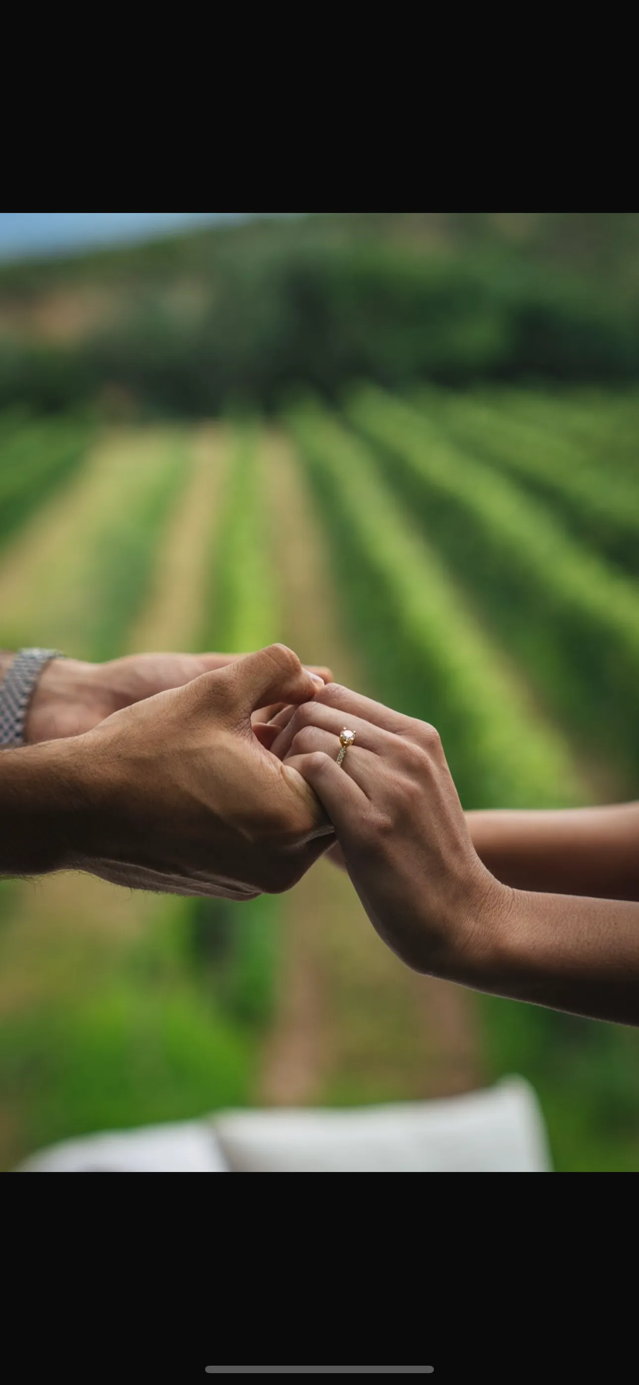 A close-up of a hand with an engagement ring, held by another hand, symbolizing love and commitment.