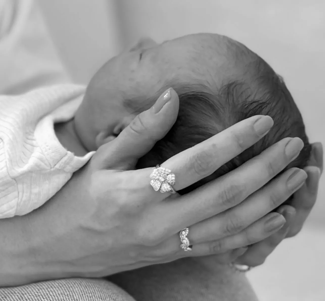 Close-up of a child's ear with a sparkling diamond earring. Shop baby earrings.