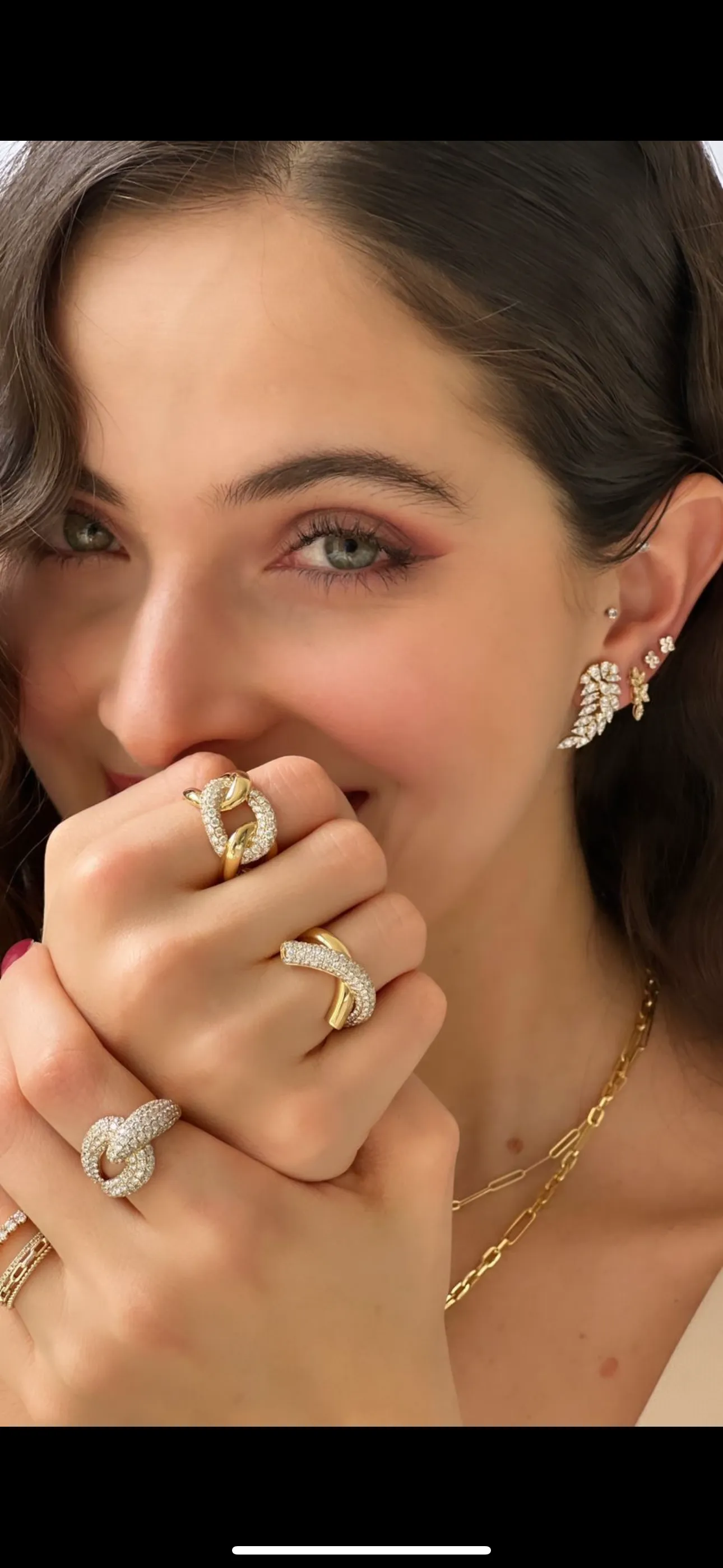 Close-up of a woman showcasing elegant jewelry, including rings and bracelets.