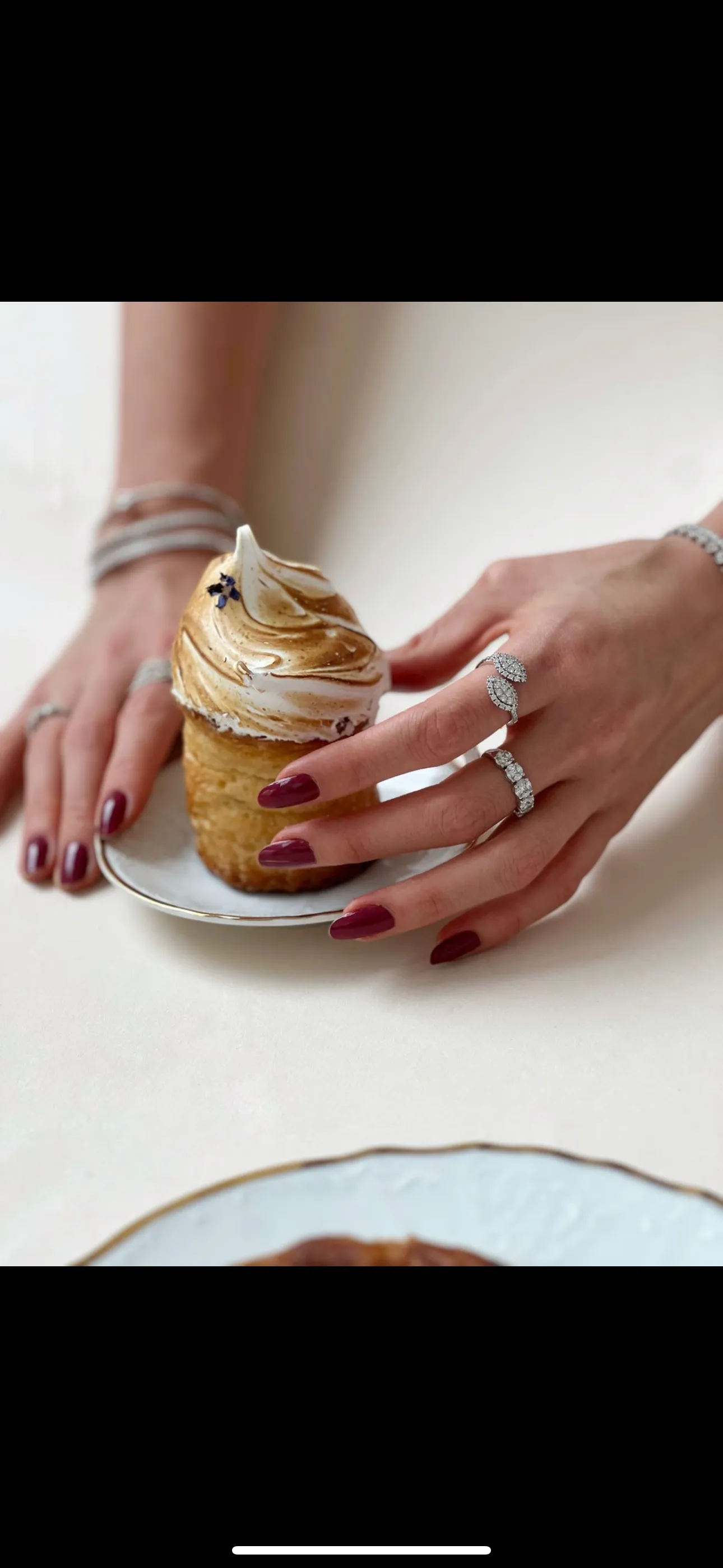 Close-up of a woman showcasing various elegant rings and earrings.