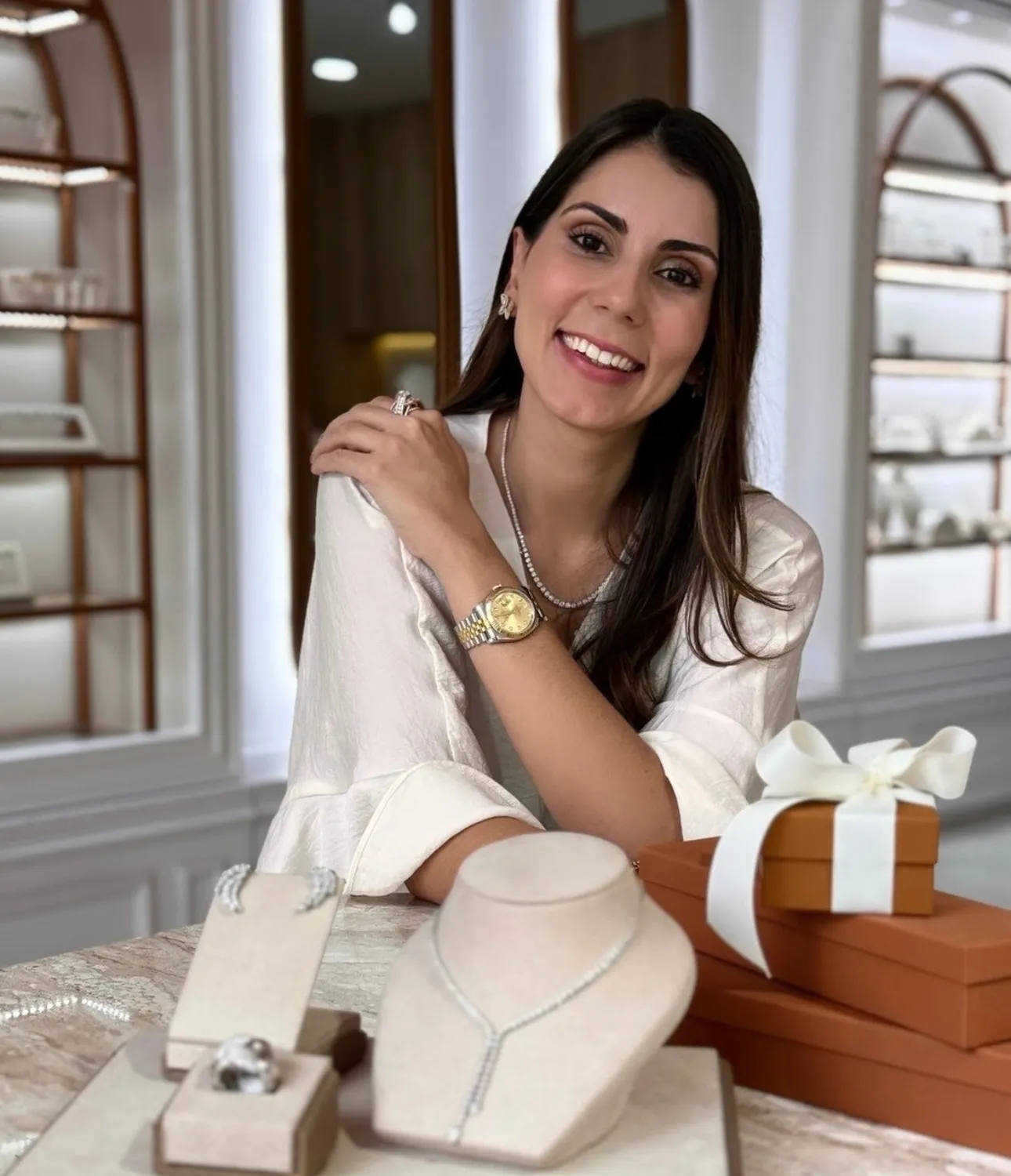 A hand holding a sparkling silver ring with a pink stone, showcasing jewelry appraisal services.