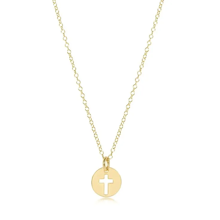 Gold cross necklace on a chain worn over a white shirt, representing faith and elegance.