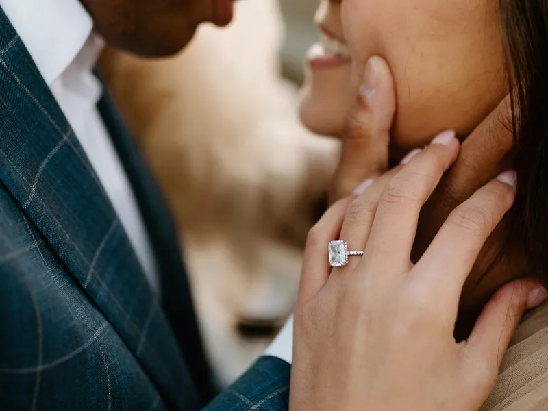 Couple sharing a romantic moment, showcasing an engagement ring.