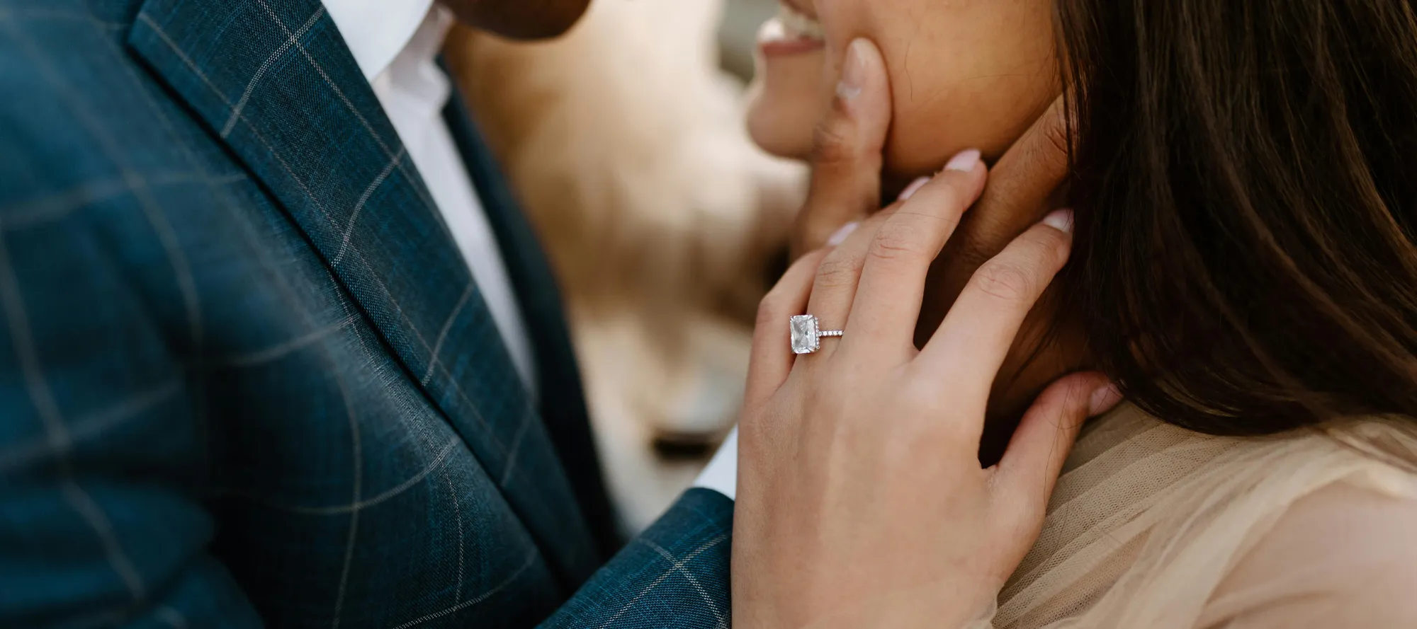 Couple sharing a romantic moment, showcasing an engagement ring.
