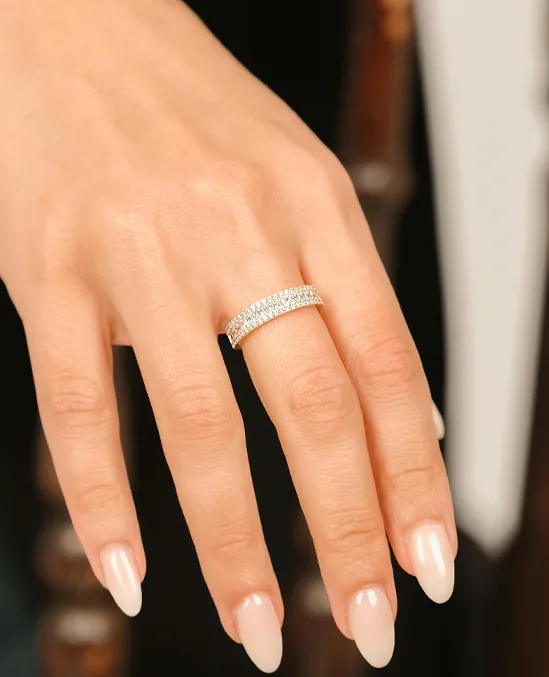 Elegant eternity band ring with sparkling diamonds on a woman's hand, showcasing fine jewelry.